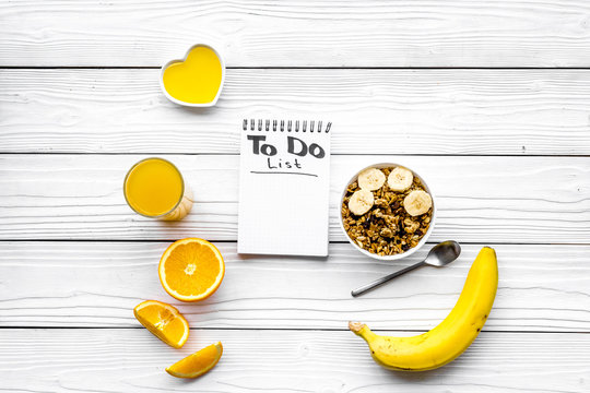 Start the day the right way. Healthy breakfast oatmeal with fruits and planning the day. White wooden background top view copy space