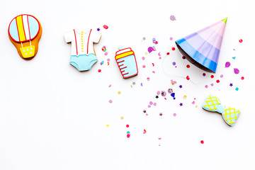 Baby shower. Cookies in shape of accesssories for child and party hats on white background top view copy space