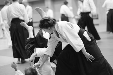 The participants of the training in special clothes of aikido hakama work out the methods of single combat