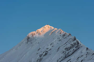 Snow-capped mountain peak with beautiful blue sky above