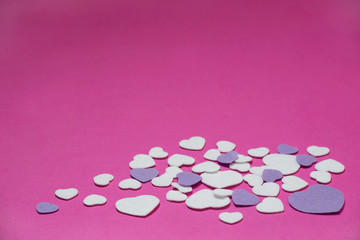 Obraz na płótnie Canvas Purple and white felt hearts on a hot pink background - valentines, love