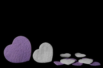 Purple and white felt hearts isolated on a black background - valentines, love