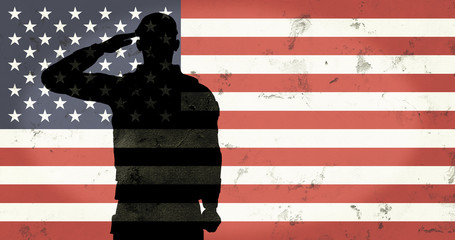 Veterans day soldier in front of grunge wall and old flag