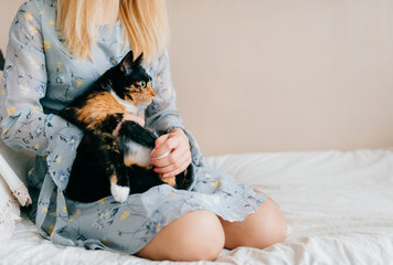 Young cute teenager with her beloved cat. Beautiful blonde girl with kind tender face hugging little purebred domestic pet. Animal lover.  Lonely female adore little kitten. Happy family at home.