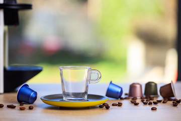 Empty coffee cup, espresso capsules and coffee beans on blur background, Closeup view with details