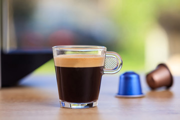 Espresso cup and coffee capsules on blur background, Closeup view with details