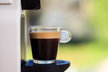 Espresso coffee machine on a blur green background, space for text