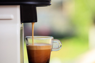 Espresso coffee machine on a blur green background, space for text