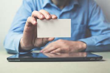 Businessman showing a business card in his business desk.