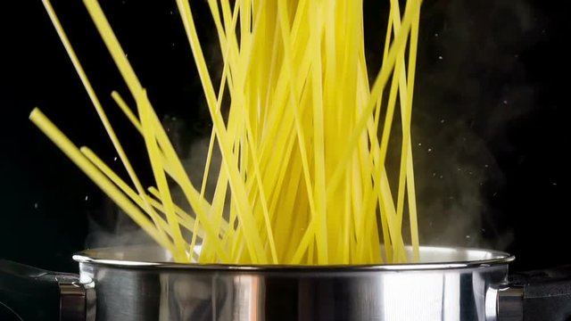 Pasta being poured into a pot of boiling water. Shot with a high speed camera.