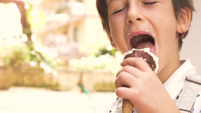 Happy cheerful young girl thumbs up while eating icecream cornetto