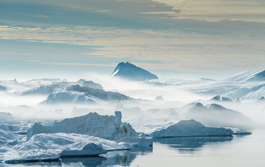 Stranded icebergs in the fog at the mouth of the Icefjord near Ilulissat, Greenland