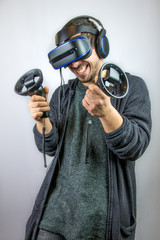 Junger Mann zockt gutgelaunt Videospiel mit Virtual Reality Datenbrille