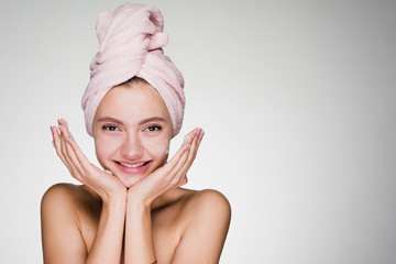 happy girl with a towel on her head after cleaning her face skin