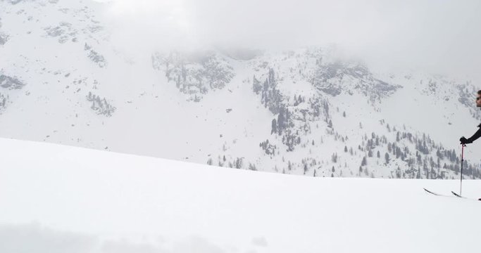 Man walking up ascending along snow ridge landscape.Mountaineering ski activity. Skier people winter sport in alpine mountain outdoor.Side view.Slow motion 60p 4k video