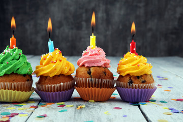 Tasty cupcakes on wooden background. Birthday cupcake in rainbow colors