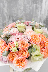 beautiful bouquet of mixed flowers in a vase on wooden table. the work of the florist at a flower shop