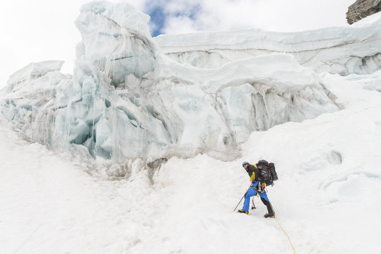 Man hiking on snow-capped mountain plateau