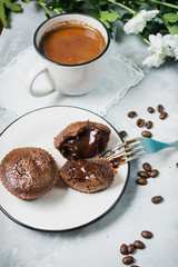 Chocolate cupcakes with a cup of hot black coffee on cocrete background