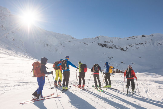 Group of skiers ski touring on snow-capped mountain plateau