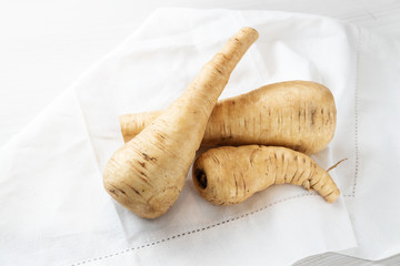 Parsnip, raw root vegetables on a white kitchen towel, copy space, selected focus