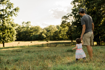 Father and Daughter Walking in Cow Pasture
