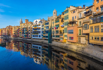 Colorful river-front houses lining the Onyar river, mostly built on top of old medieval defense walls, Girona, Catalonia, Spain
