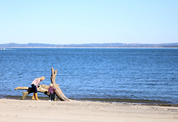 Mother and child at the beach on a sunny day.
