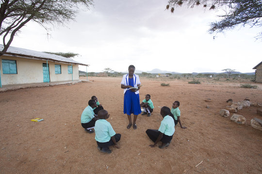 Teacher teaching students outdoors
