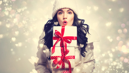 Young woman holding stack of Christmas gift boxes
