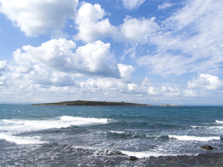 Waves on cliffs coast. Rocky coastline of Black Sea. Dramatic sky background