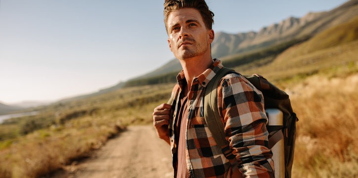 Young man with backpack on country walk