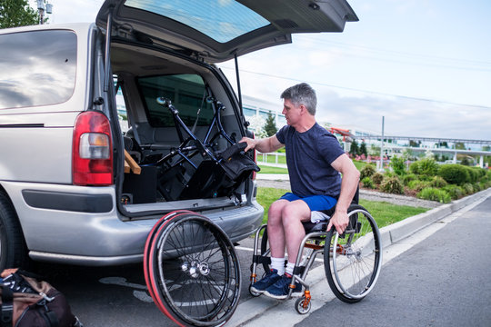 Active Disabled Athlete Taking Out Wheelchair From His Car
