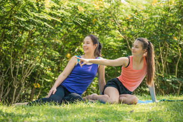young yoga woman showing a way by finger for her sister in park