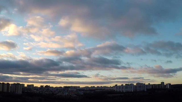 Time lapse evening clouds over city, beginning of sunset and night