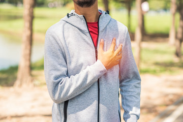 sport man having chest pain after running in the park , heart attack