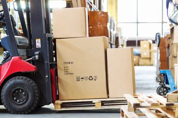 forklif  with a three large cardboard boxes in a modern warehous - obrazy, fototapety, plakaty