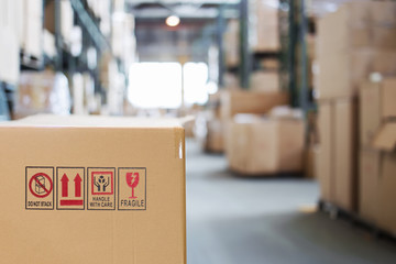 Cardboard box with goods on the background of a blurry modern warehouse