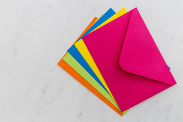 Colorful envelopes on white marble background