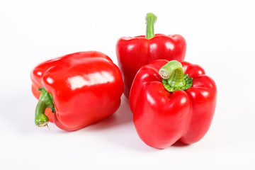 Fresh red peppers lying on white background, healthy nutrition concept