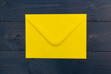 Bright yellow envelope on blue wood table