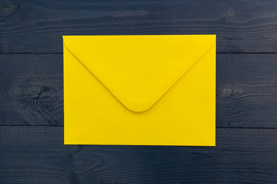 Bright Yellow Envelope On Blue Wood Table