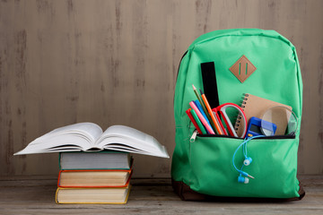 Naklejka premium Education concept - school backpack with books and other supplies on the desk