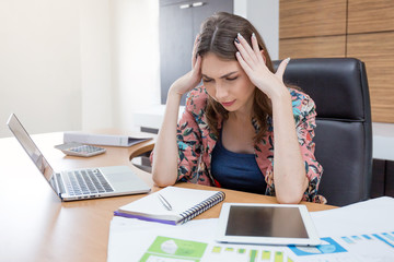 Woman headache after hard work in her office.