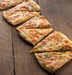 slices of delicious pizza with cheese and ham and tomatoes closeup