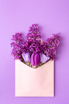 Purple lilac and tulips in an envelope