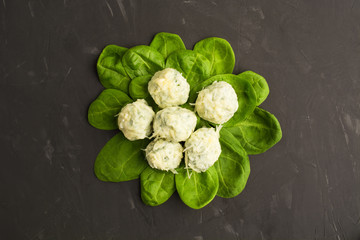 Cooked gnocchi over green fresh spinach leaves with cheese, Flat lay