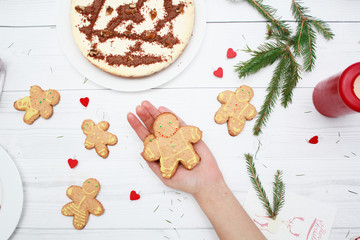 Cheesecake with chocolate on the wooden background top view. Fir branches. Christmas gingerbread man cookies. New Year's ginger biscuits