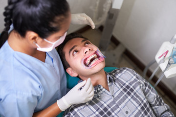 Dentist performing treatment with patient with braces