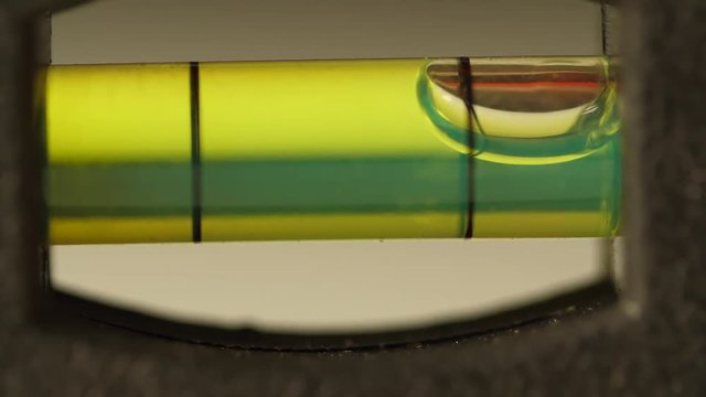 Carpenter's spirit level close up. Measuring the flatness with a spirit level. Level bubble up macro